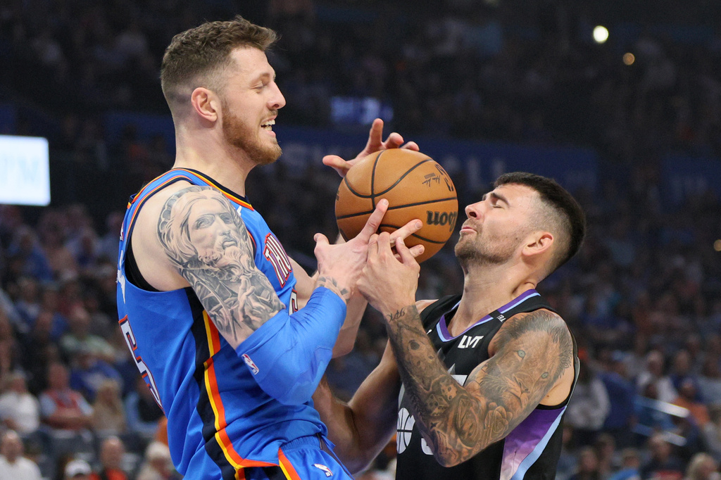 Utah Jazz guard John Konchar, right, knocks the ball away from Oklahoma City Thunder center Isaiah Hartenstein, left, during the first half of an NBA basketball game Sunday, April 5, 2026, in Oklahoma City. (AP Photo/Nate Billings)
