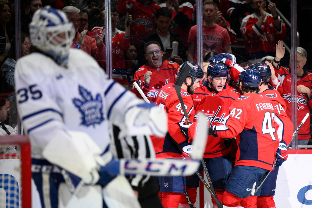 Washington Capitals center Aliaksei Protas celebrates his goal with teammates during the first period of an NHL hockey game against Toronto Maple Leafs goaltender Dennis Hildeby (35), Thursday, Dec. 18, 2025, in Washington. (AP Photo/Nick Wass)