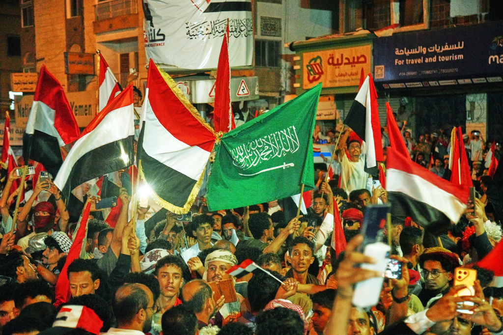 Yemenis wave national and Saudi flags as they celebrate the 64th anniversary of the September 26 Revolution in Taiz, Yemen, Friday, Sept. 25, 2026. (AP Photo/Abdulnasser Alseddik)