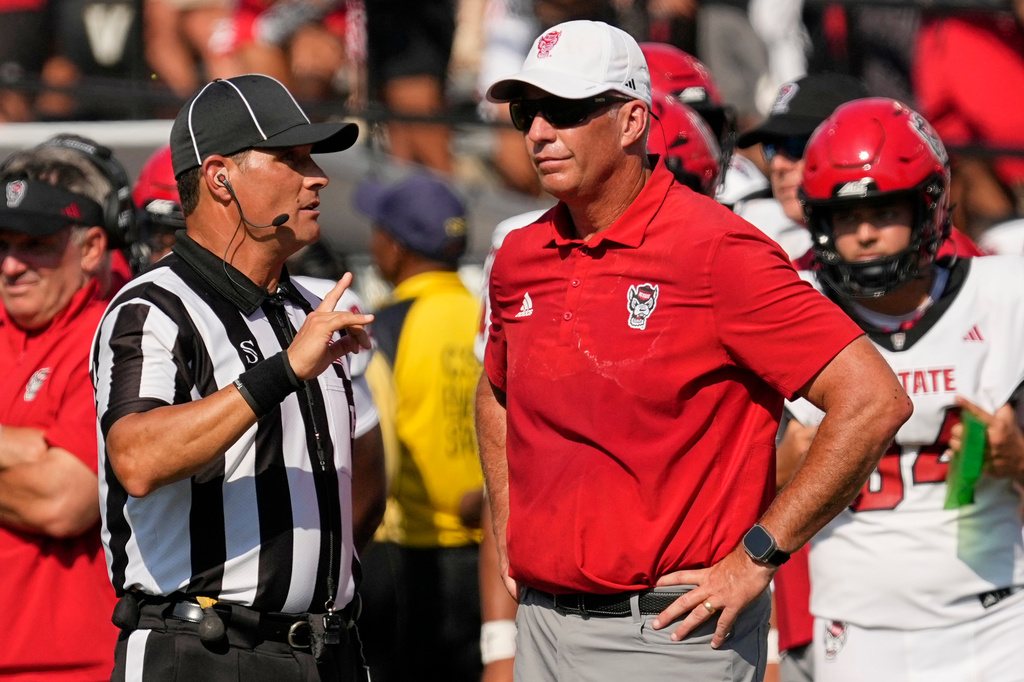 North Carolina State head coach Dave Doeren, right, talks to an official during the second half of an NCAA college football game against Vanderbilt, Saturday, Sept. 19, 2026, in Nashville, Tenn. (AP Photo/George Walker IV)