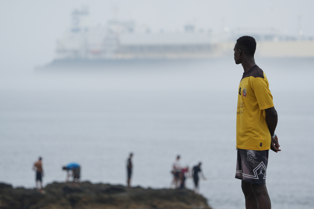 Migrants stand at El Trampolín beach in the Spanish exclave of Ceuta, Wednesday, Sept. 2, 2026. (AP Photo/Francis González)
