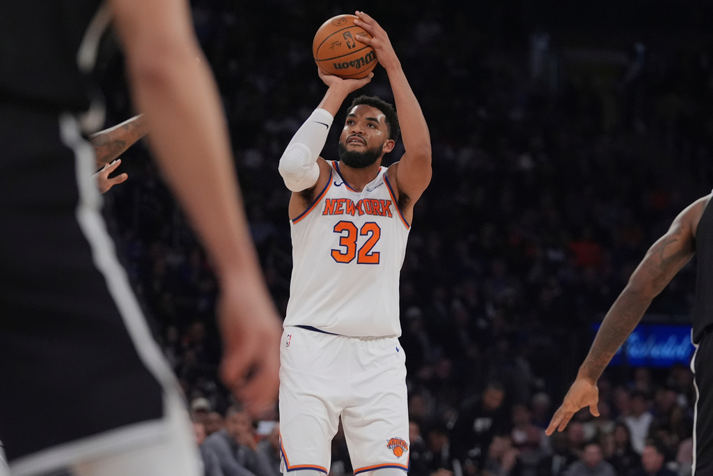 New York Knicks' Karl-Anthony Towns (32) shoots over Brooklyn Nets defenders during the first half of an NBA basketball game Sunday, Nov. 9, 2025, at Madison Square Garden in New York. (AP Photo/Frank Franklin II)