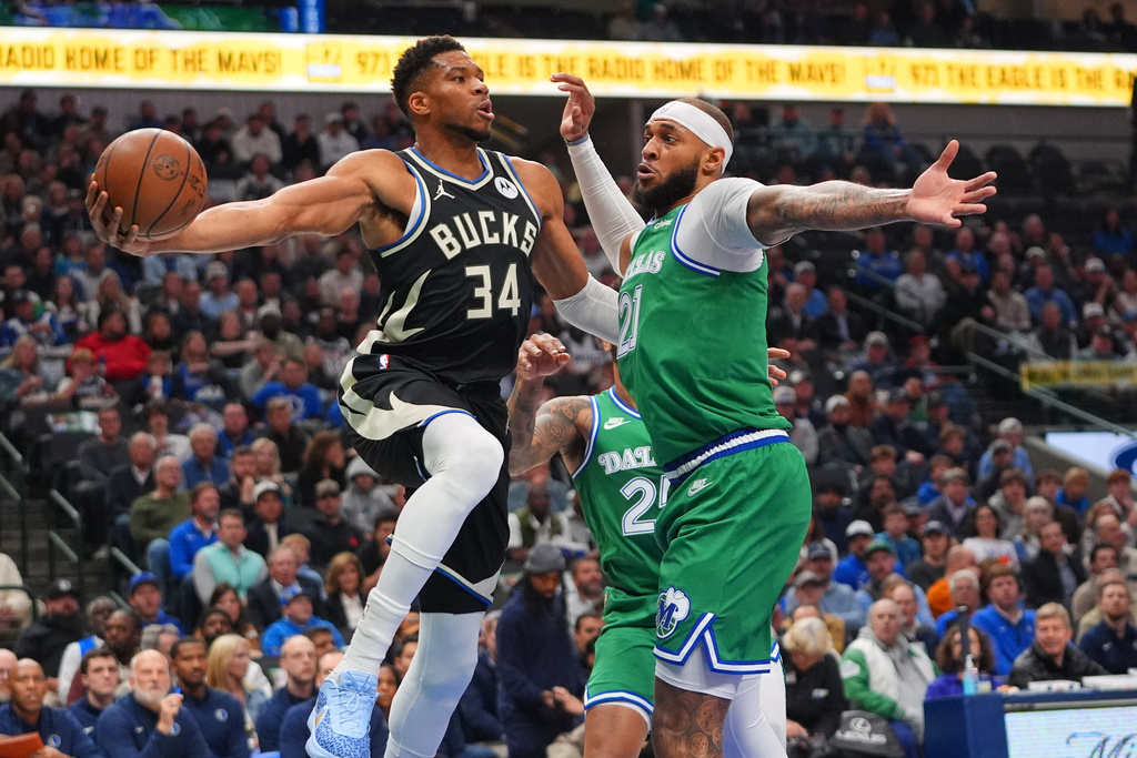 Milwaukee Bucks forward Giannis Antetokounmpo (34) moves the ball against Dallas Mavericks forward Daniel Gafford during the first half of an NBA basketball game in Dallas, Monday, Nov. 10, 2025. (AP Photo/LM Otero)