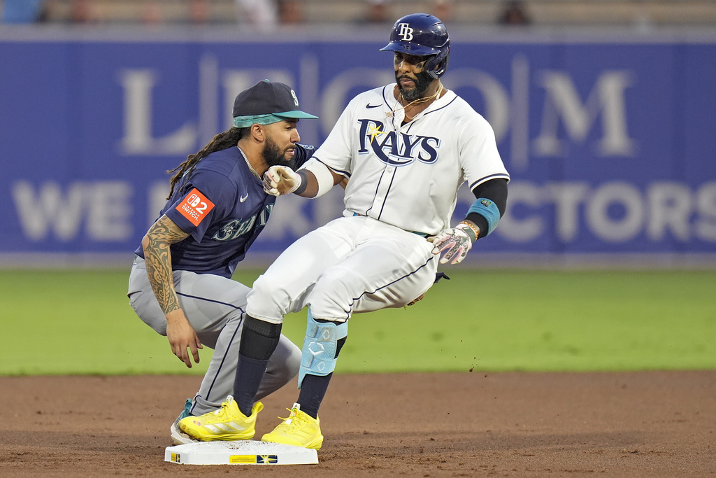 Tampa Bay Rays' Yandy Díaz, right, gets into second base ahead of the tag by Seattle Mariners shortstop J.P. Crawford with a double during the first inning of a baseball game Wednesday, Sept. 3, 2025, in Tampa, Fla. (AP Photo/Chris O'Meara)