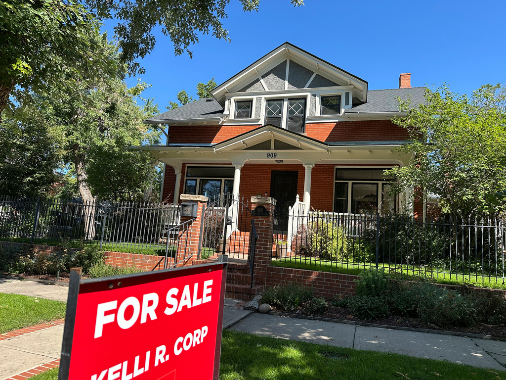 FILE - A for sale sign stands outside a home on the market in the Alamo Placita neighborhood Tuesday, Aug. 27, 2024, in central Denver. (AP Photo/David Zalubowski, File)