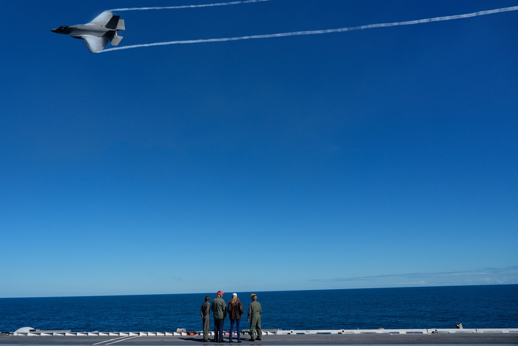 President Donald Trump and first lady Melania Trump watch a naval sea power demonstration, part of the Navy's 250th anniversary celebration, aboard the USS George H.W. Bush aircraft carrier in the Atlantic Ocean off the coast of Norfolk, Va., Sunday, Oct. 5, 2025. (AP Photo/Alex Brandon)