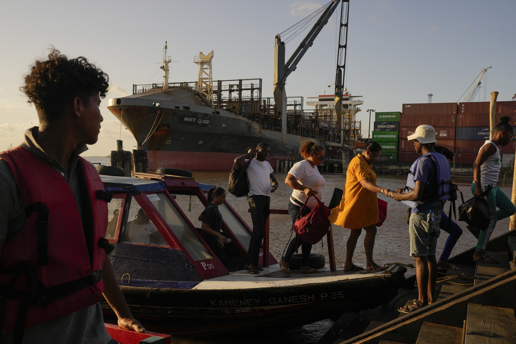 Travelers disembark at Stabroek Market a day ahead of the general elections in Georgetown, Guyana, Sunday, Aug. 31, 2025.(AP Photo/Matias Delacroix)