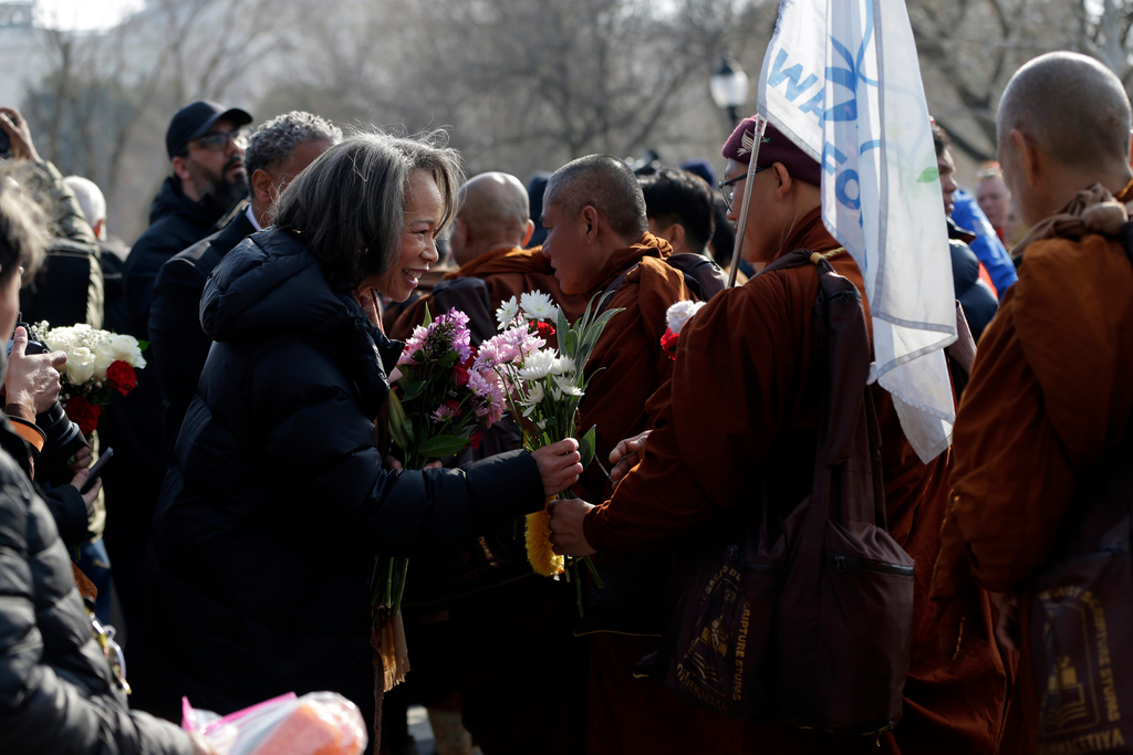Sen. Lisa Blunt Rochester, D-DE., left, greeting Buddhist monks as they walk near the Peace Monument on Capitol Hill, during the Walk For Peace, Wednesday, Feb. 11, 2026, in Washington. (AP Photo/Rahmat Gul)