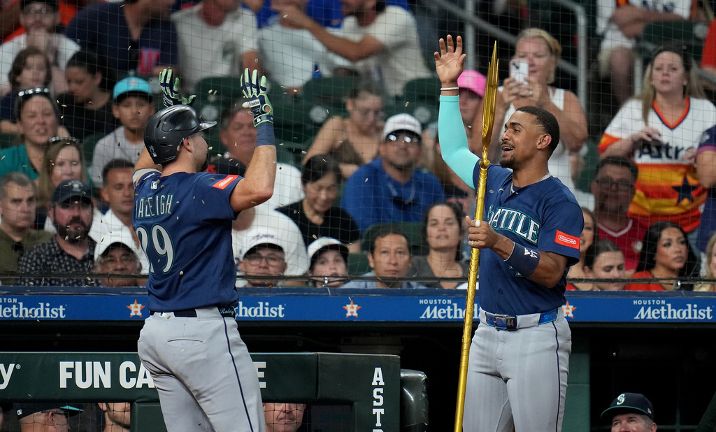 Seattle Mariners' Julio Rodriguez, right, sprinkles Cal Raleigh, left, with sunflower seeds after Raleigh's solo home run during the sixth inning of a baseball game against the Houston Astros, Sunday, Aug. 16, 2026, in Houston. (AP Photo/Karen Warren)