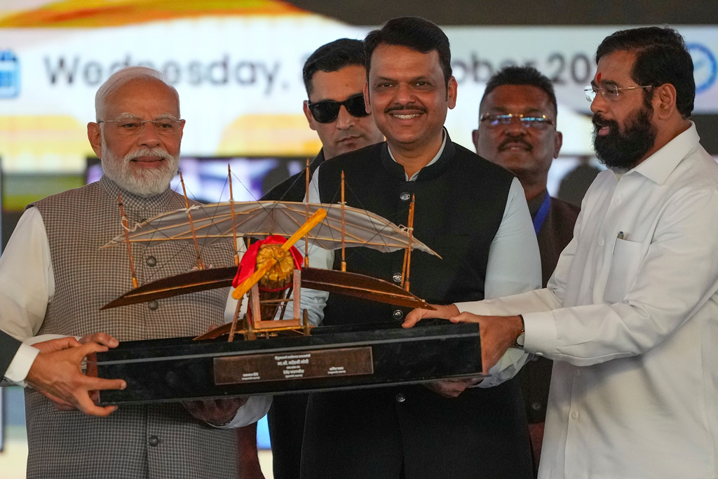 Maharashtra Deputy Chief Minister Eknath Shinde, right, and Maharashtra Chief Minister Devendra Fadnavis, centre, present a replica of a vintage plane to Indian Prime Minister Narendra Modi, left, during the inauguration ceremony of the Navi Mumbai International Airport in Navi Mumbai, India, Wednesday, Oct. 8, 2025. (AP Photo/Rafiq Maqbool)