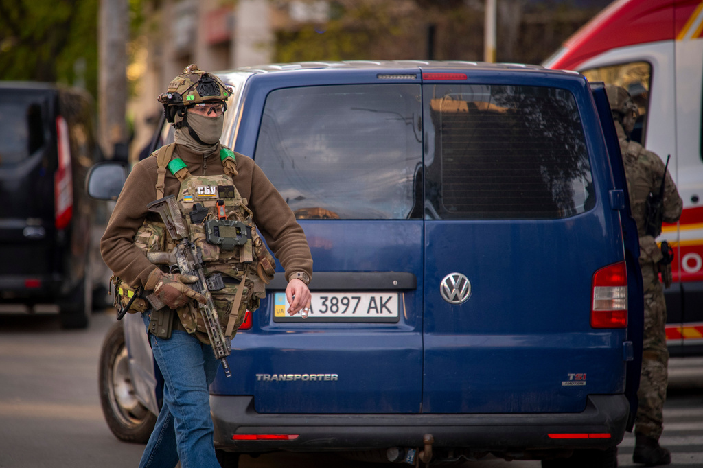 A police officer is seen at the site where a gunman killed at least six people in the streets before being shot dead by police, in Kyiv, Ukraine, Saturday, April 18, 2026. (AP Photo/Dan Bashakov)