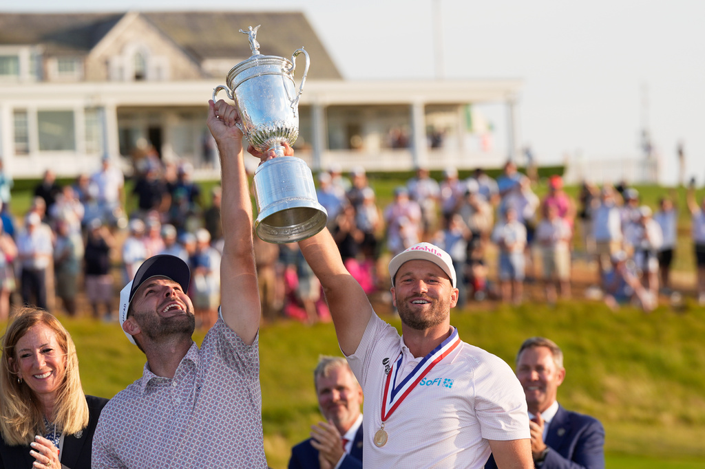 Wyndham Clark celebrates with his caddie David Pelekoudas after winning the U.S. Open golf tournament at Shinnecock Hills Golf Club in Southampton, N.Y., Sunday, June 21, 2026. (AP Photo/David J. Phillip)