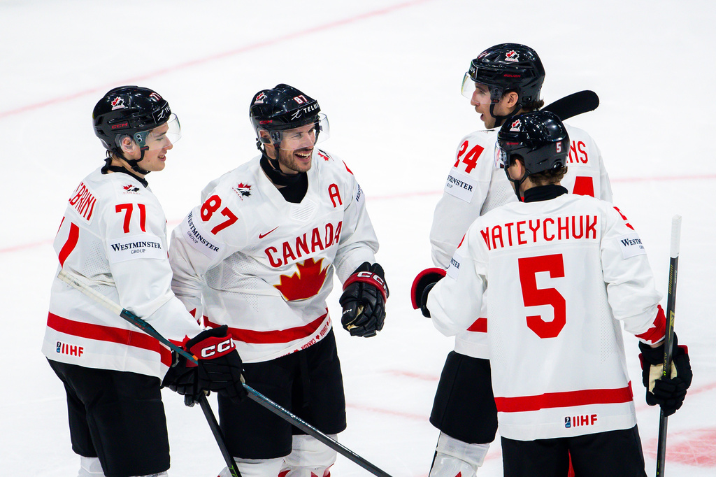 Canada's Dylan Cozens, second right, celebrates his goal with his teammates Canada's Canada's Macklin Celebrini, left, Sidney Crosby, left, and Canada's Denton Mateychuk, right, centre, after scoring during a preliminary round game between Canada and Slovenia at the men's ice hockey world championship in Fribourg, Switzerland, Friday May 22, 2026. (Salvatore Di Nolfi/Keystone via AP)