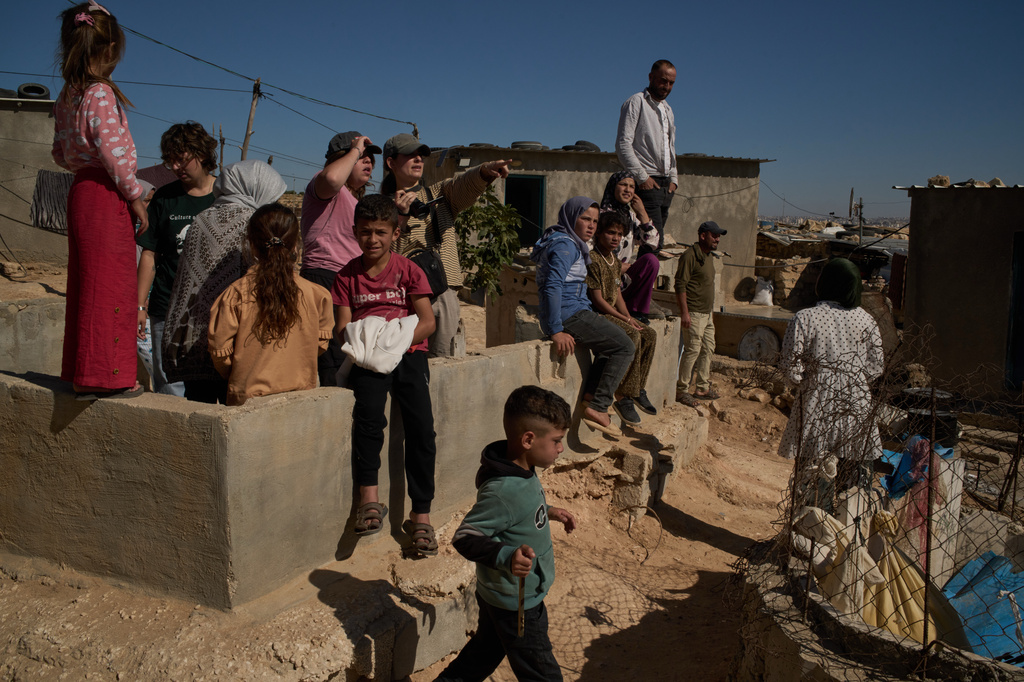 Israeli activists along with Palestinians from a local community observe the movement of settlers near the West Bank village of Susya, in the Masafer Yatta region, Thursday, June 18, 2026. (AP Photo/Leo Correa)