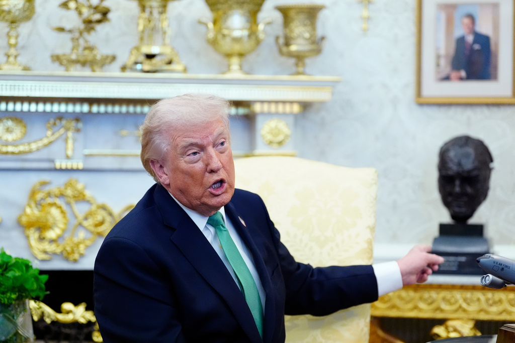 President Donald Trump points to a bust of Winston Churchill as he speaks during a meeting with Irish Prime Minister Micheál Martin in the Oval Office of the White House, on St. Patrick's Day, Tuesday, March 17, 2026, in Washington. (AP Photo/Alex Brandon)