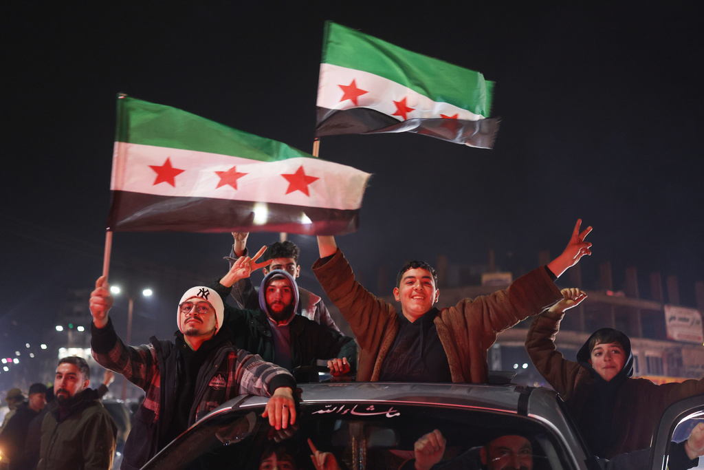 People celebrate as Syrian government troops take control of the town from the Syrian Democratic Forces (SDF) in Raqqa, northeastern Syria, Sunday, Jan. 18, 2026. (AP Photo/Ghaith Alsayed)