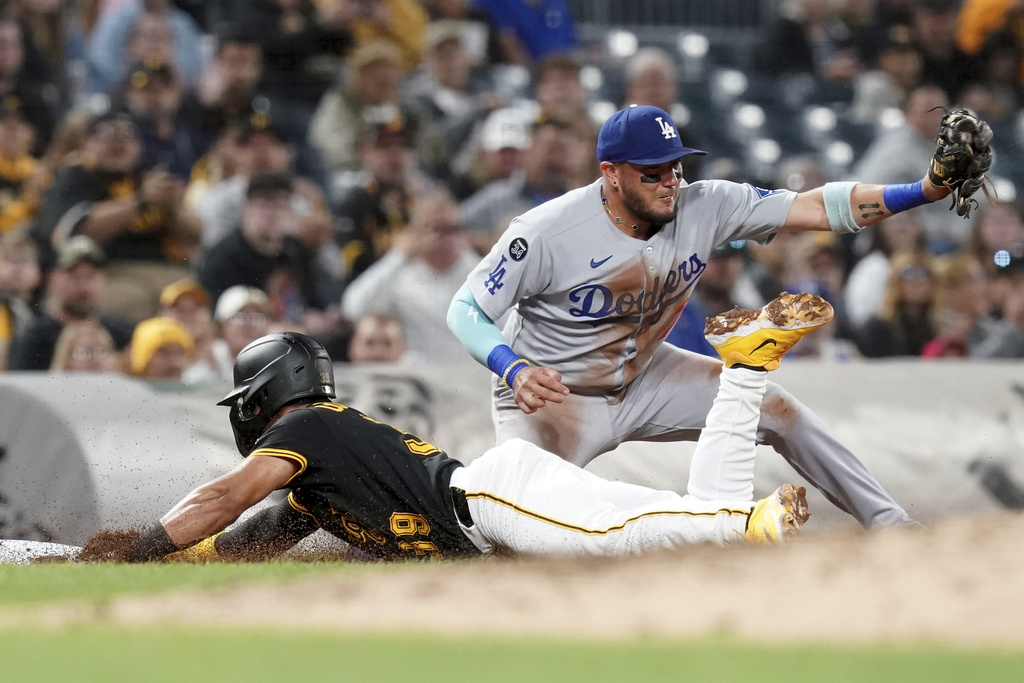 Pittsburgh Pirates' Nick Gonzales, bottom, slides safely into third on a single by Bryan Reynolds as Los Angeles Dodgers third baseman Miguel Rojas, top, waits for the late throw during the fifth inning of a baseball game Thursday, Sept. 4, 2025, in Pittsburgh. (AP Photo/Matt Freed)