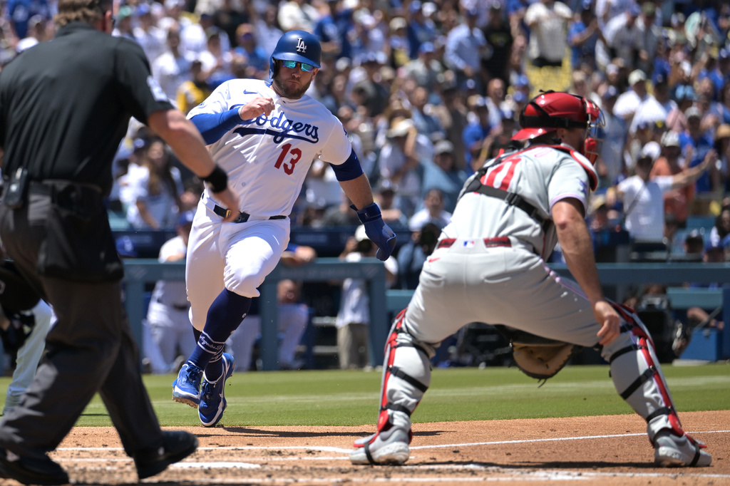 Los Angeles Dodgers' Max Muncy (13) beats a throw to Philadelphia Phillies catcher J.T. Realmuto, right, for a run during the second inning of a baseball game Sunday, May 31, 2026, in Los Angeles. (AP Photo/Jayne Kamin-Oncea)