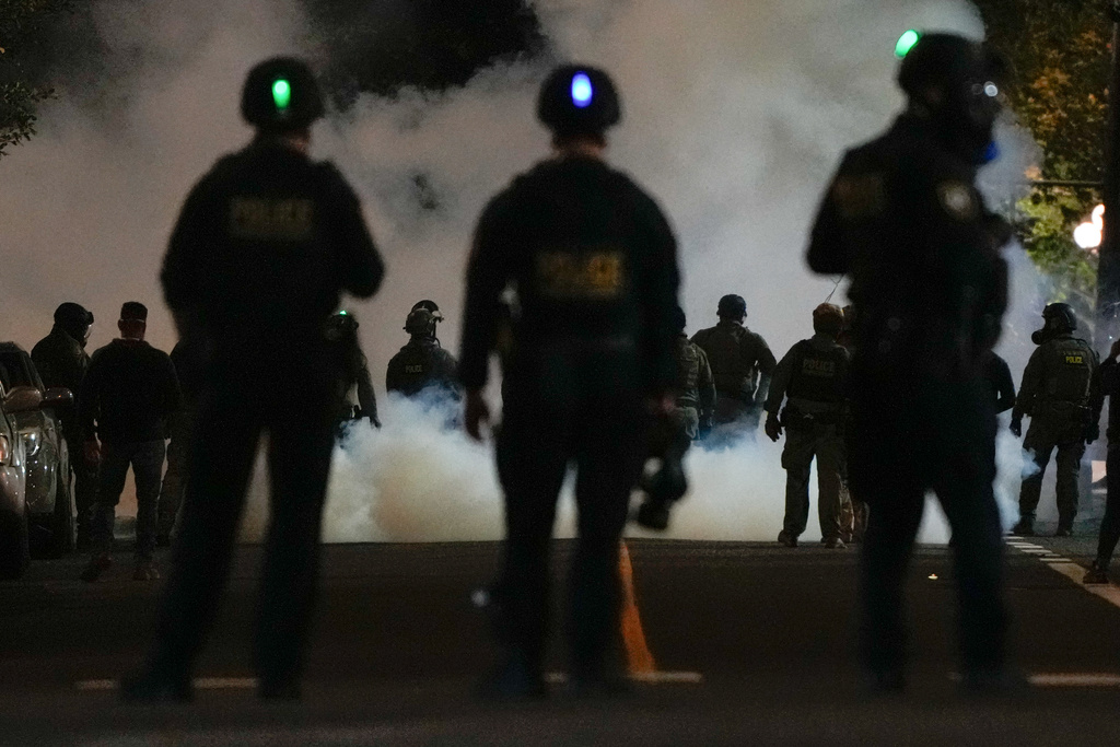 Law enforcement officers stand after deploying tear gas outside a U.S. Immigration and Customs Enforcement facility during a protest on Saturday, Oct. 4, 2025, in Portland, Ore. (AP Photo/Jenny Kane)
