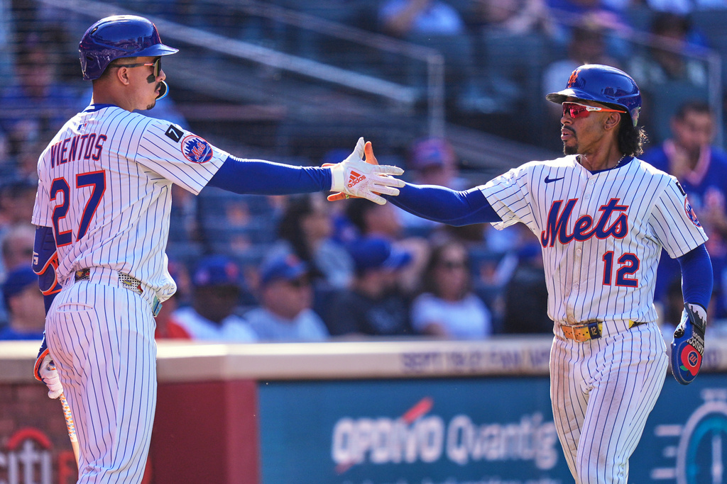 New York Mets' Francisco Lindor, right, is greeted by Mark Vientos after scoring a run on a sacrifice fly hit by Juan Soto during the seventh inning of a baseball game against the San Diego Padres, Thursday, Sept. 18, 2025, in New York. (AP Photo/Seth Wenig)