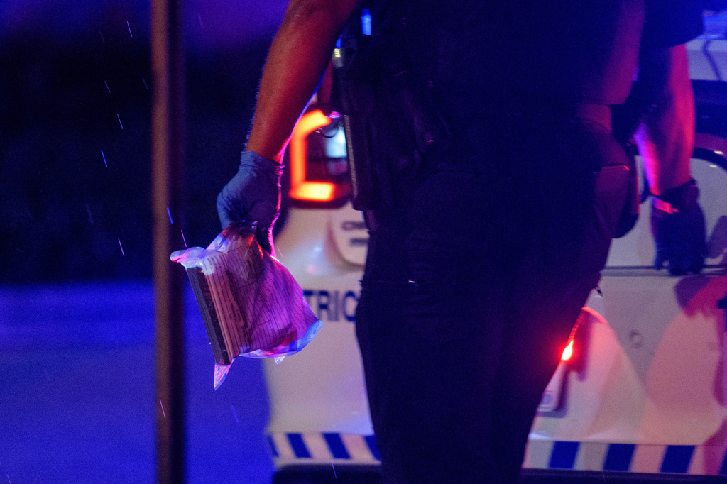 FILE - A Washington D.C. Metro police office carries an evidence bag to his car as law enforcement work the scene after two staff members of the Israeli Embassy in Washington were shot and killed outside the Capital Jewish Museum, May 22, 2025, in Washington. (AP Photo/Rod Lamkey, Jr., File)