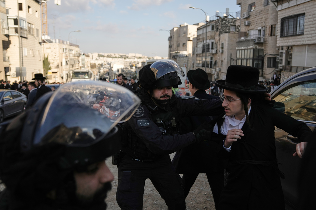Israeli police officers scuffle with young Ultra-Orthodox Jewish protesters during a violent disturbance in Jerusalem, Thursday, Dec. 18, 2025. (AP Photo/Mahmoud Illean)