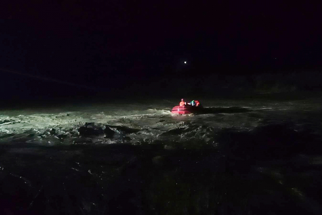 In this photo provided by the Philippine Coast Guard, rescuers use a rubber boat to help evacuate residents along a swollen river as Super Typhoon Ragasa affects Salcedo, Ilocos Sur province, northern Philippines, Monday, Sept. 22, 2025. (Philippine Coast Guard via AP)