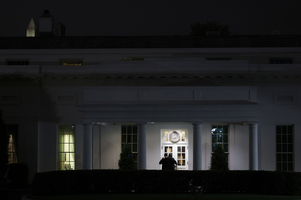 People are seen outside the West Wing driveway entrance of the White House, Saturday, April 25, 2026, in Washington. (AP Photo/Tom Brenner)