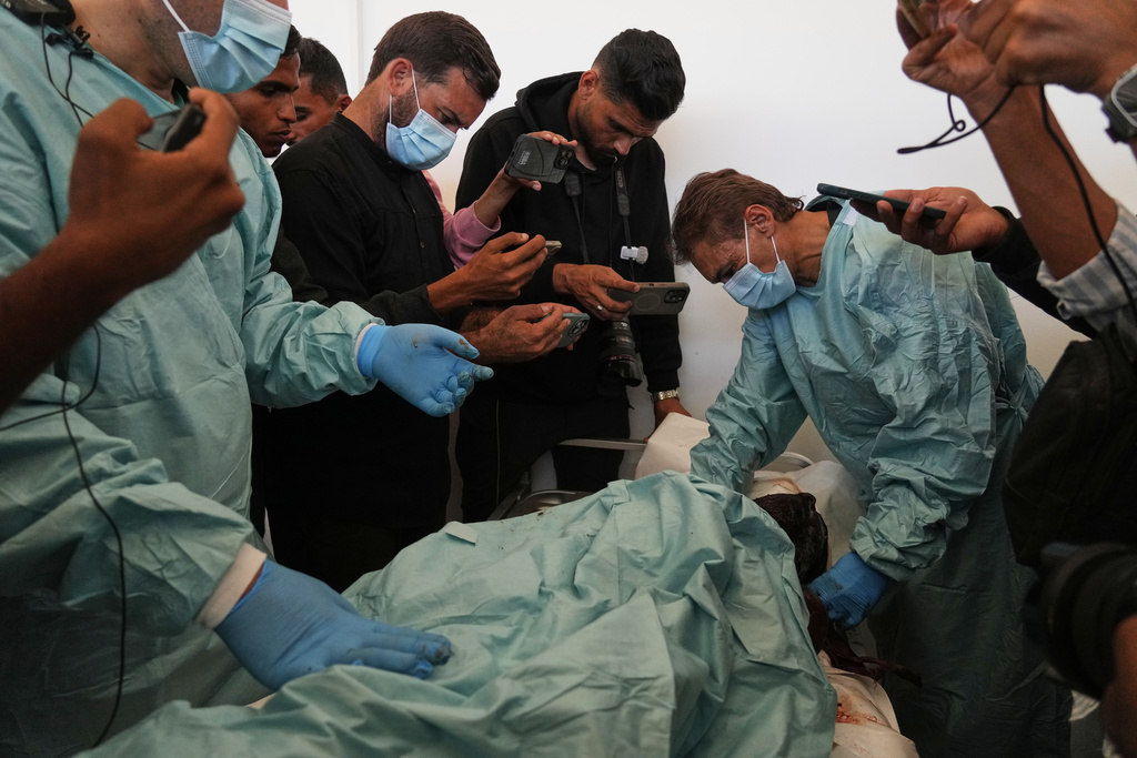 Palestinian doctors examine the bodies of Palestinians held by Israel during the war, as part of the identification process at Nasser Hospital in Khan Younis, southern Gaza Strip, Saturday, Oct. 18, 2025. (AP Photo/Abdel Kareem Hana)