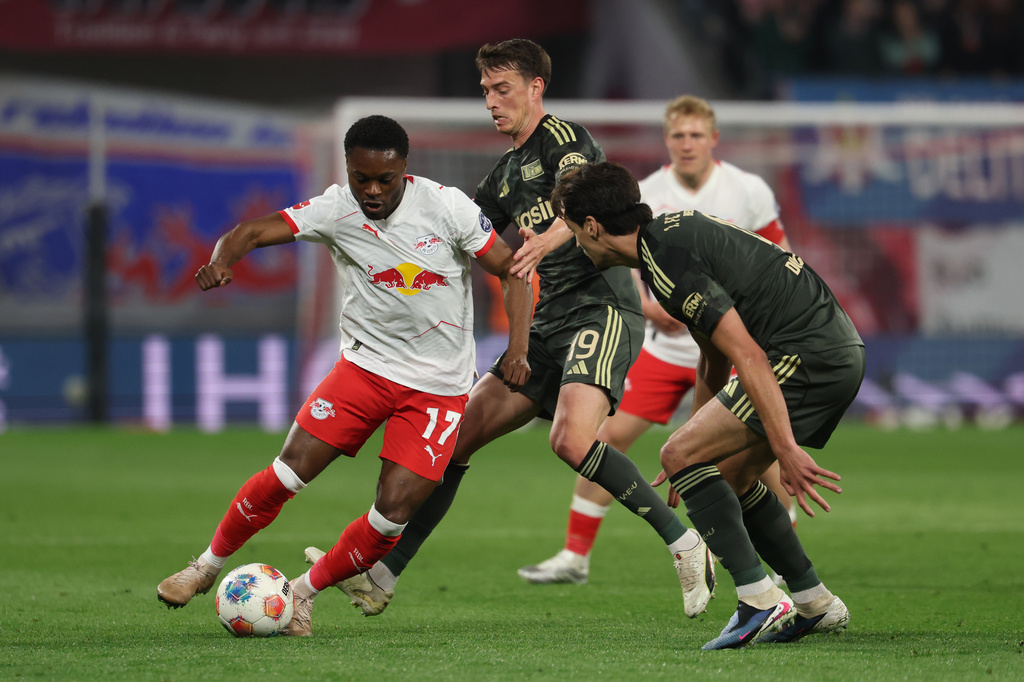 Leipzig's Ridle Baku, left, dribbles as Union Berlin's Janik Haberer, center, and Diogo Leite defend during a Bundesliga soccer match between RB Leipzig and 1. FC Union Berlin, Friday, April 24, 2026, in Leipzig, Germany. (Jan Woitas/dpa via AP)