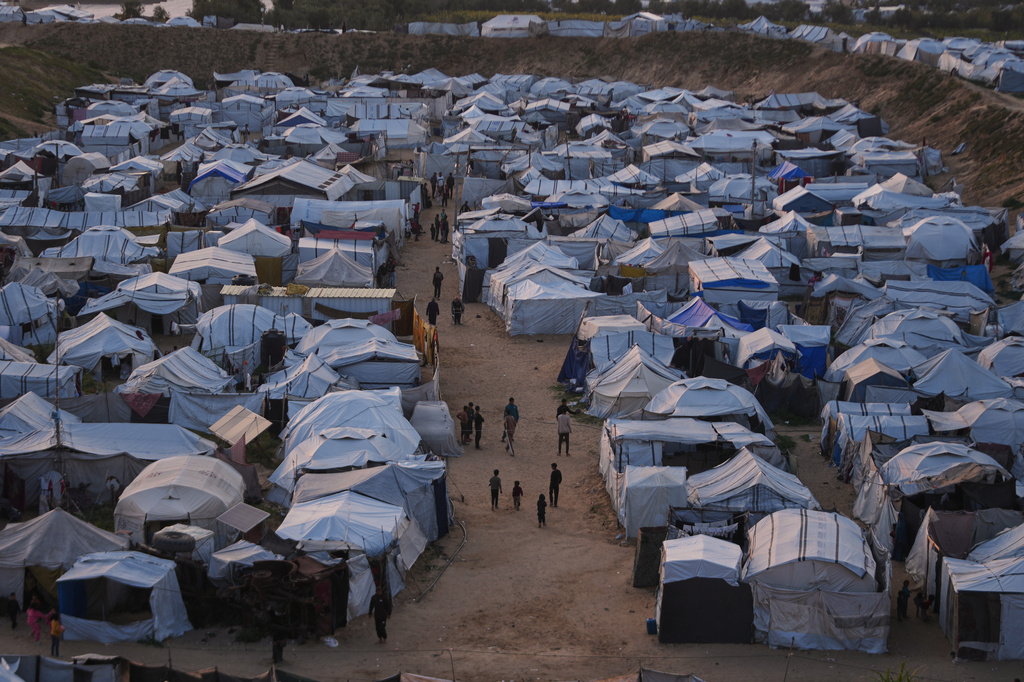 Palestinians walk along tents at a makeshift camp for displaced people in Khan Younis, southern Gaza Strip, Thursday, April 9, 2026. (AP Photo/Abdel Kareem Hana)