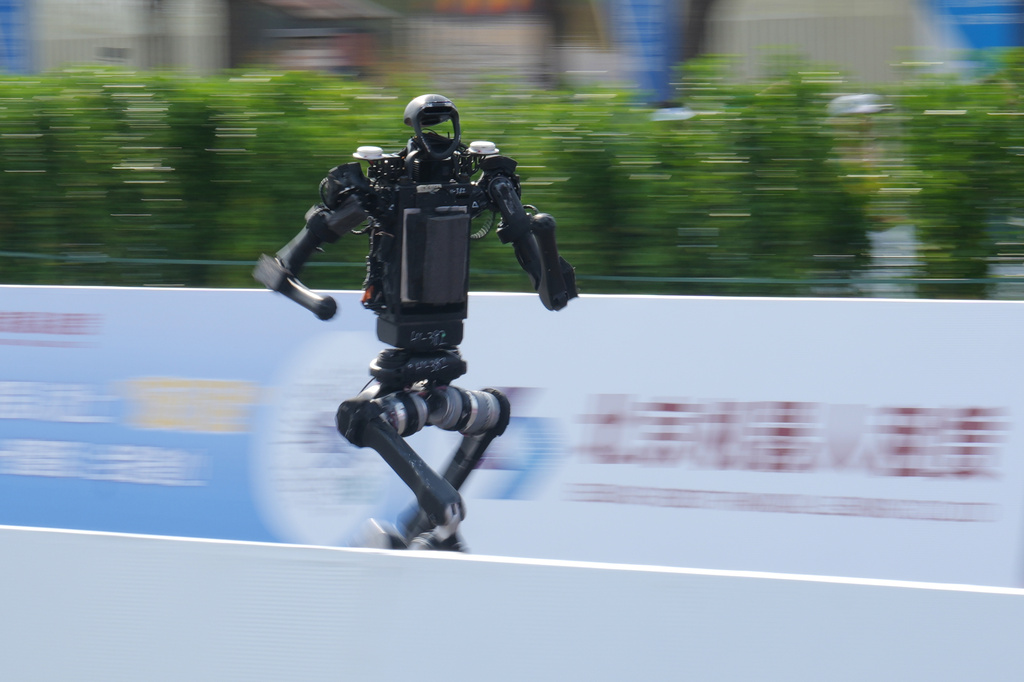 A robot runs as it competes in the Beijing E-Town Half Marathon and Humanoid Robot Half-Marathon on the outskirts of Beijing, Sunday, April 19, 2026. (AP Photo/Andy Wong)