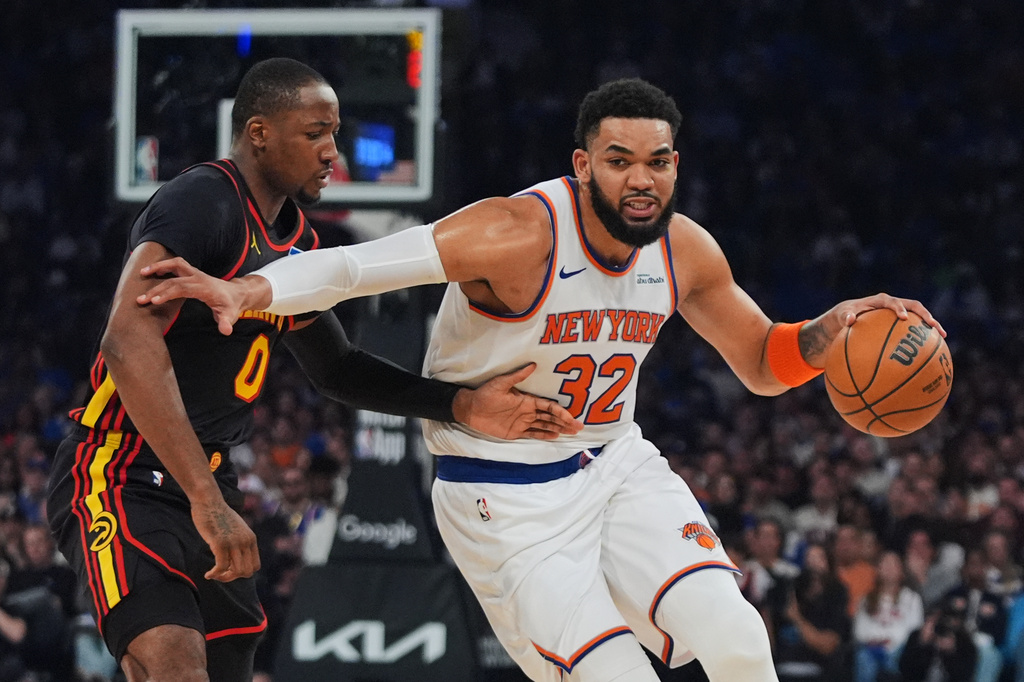 New York Knicks' Karl-Anthony Towns (32) drives past Atlanta Hawks' Jonathan Kuminga (0) during the first half in Game 1 of a first-round NBA playoffs basketball series, Saturday, April 18, 2026, in New York. (AP Photo/Frank Franklin II)