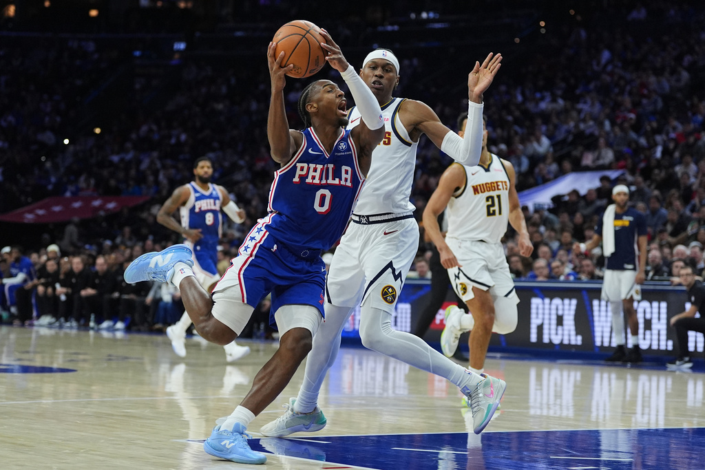 Philadelphia 76ers' Tyrese Maxey (0) goes up to shoot against Denver Nuggets' Peyton Watson during the first half of an NBA basketball game Monday, Jan. 5, 2026, in Philadelphia. (AP Photo/Matt Rourke)