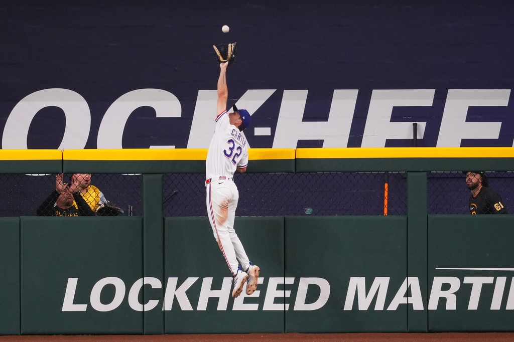 Texas Rangers outfielder Evan Carter goes up to rob a three-run home run on a ball hit by Pittsburgh Pirates' Oneil Cruz during the fifth inning of a baseball game Tuesday, April 21, 2026, in Arlington, Texas. (AP Photo/Julio Cortez)