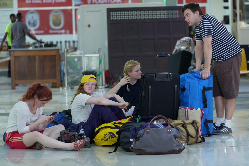 Stranded passengers wait for their delayed flights at the Zanzibar International Airport, Tanzania, Friday, Oct. 31, 2025. (AP Photo/Brian Inganga)