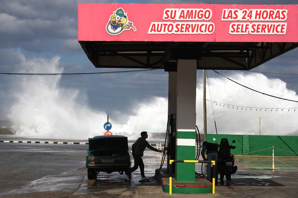 People refuel their car and motorcycle at a gas station near the Malecon in Havana, Cuba, Tuesday, Jan. 27, 2026. (AP Photo/Ramon Espinosa)
