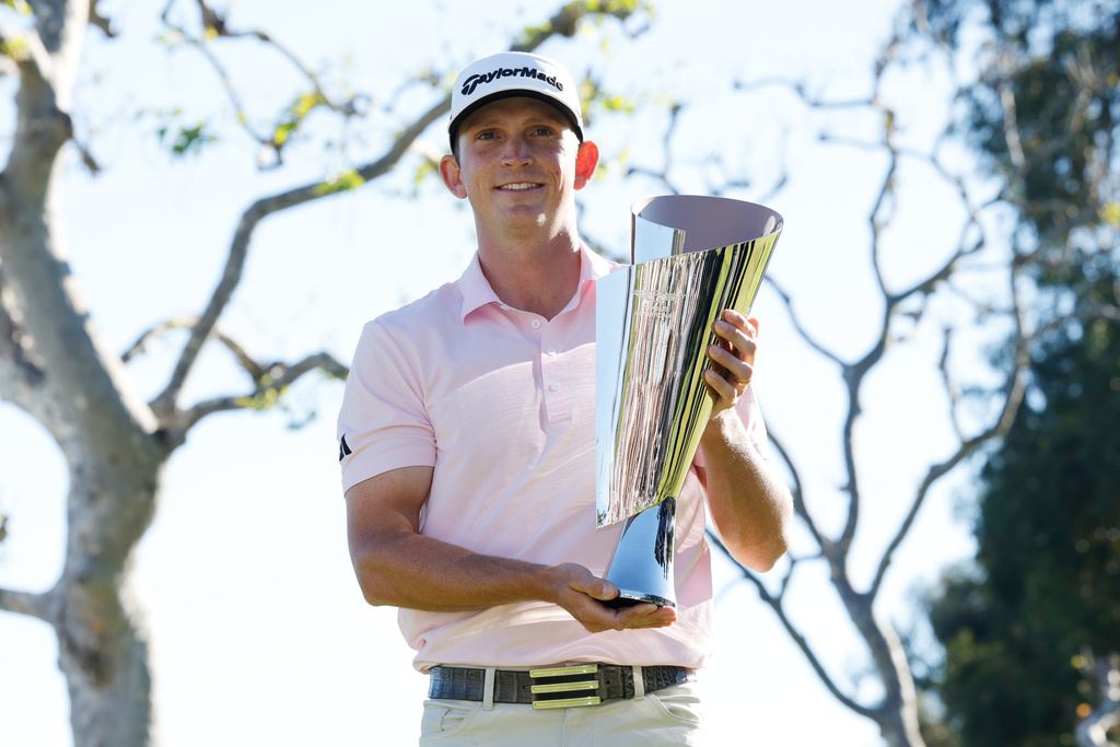 Jacob Bridgeman poses with the winner's trophy after winning the Genesis Invitational golf tournament at Riviera Country Club, Sunday, Feb. 22, 2026, in the Pacific Palisades area of Los Angeles. (AP Photo/Caroline Brehman)