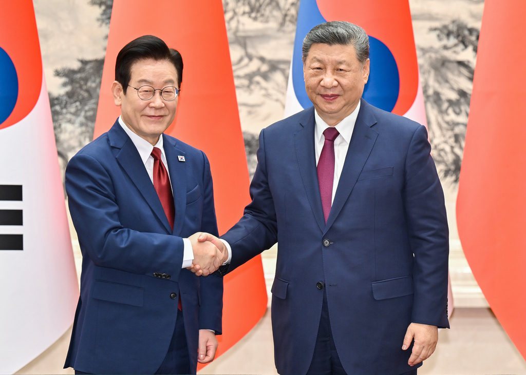 In this photo released by Xinhua News Agency, visiting South Korean President Lee Jae Myung, left, shakes hands with Chinese President Xi Jinping prior to their bilateral meeting at the Great Hall of the People, in Beijing, Monday, Jan. 5, 2026. (Yue Yuewei/Xinhua via AP)