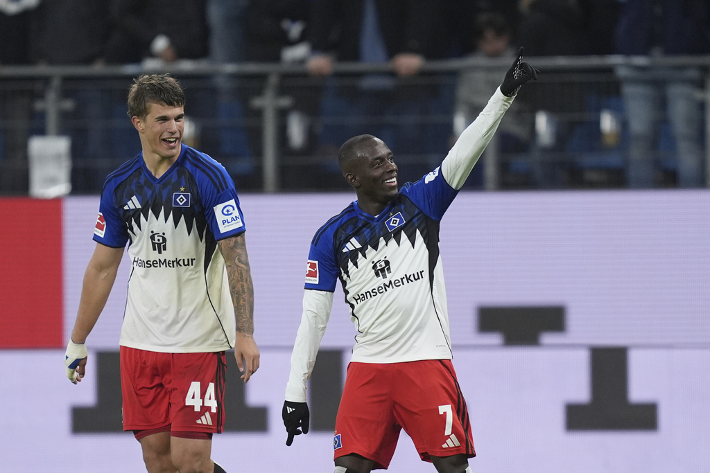 Hamburger's Jean-Luc Dompé, right, celebrates scoring with Luka Vusskovic during the Bundesliga soccer match between Hamburger SV and FSV Mainz 05 at the Volksparkstadion, Hamburg, Germany, Sunday Oct. 5, 2025. (Marcus Brandt/dpa via AP)