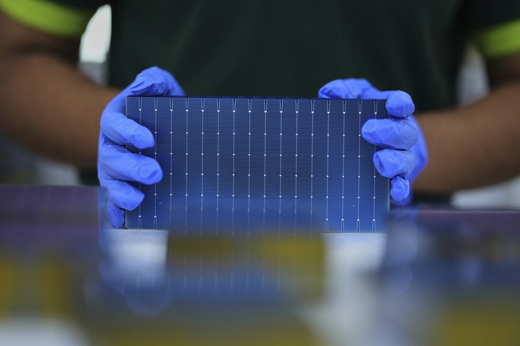 A worker stacks single solar cells at a ReNew manufacturing plant on the outskirts of Jaipur, India, Thursday, Aug. 21, 2025. (AP Photo/Manish Swarup)