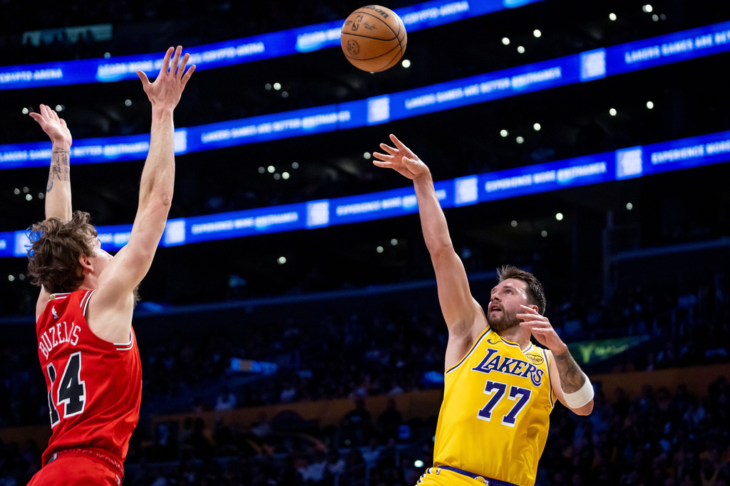 Los Angeles Lakers guard Luka Doncic (77) shoots against Chicago Bulls forward Matas Buzelis (14) during the first half of an NBA basketball game against the Chicago Bulls, Thursday, March 12, 2026, in Los Angeles. (AP Photo/Ethan Swope)