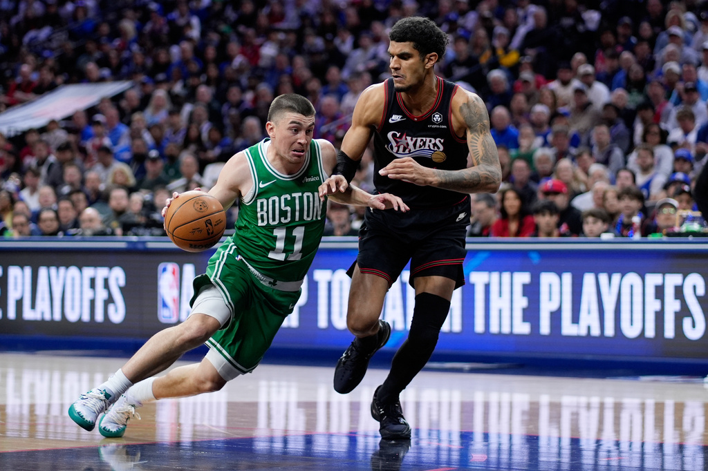 Boston Celtics' Payton Pritchard, left, tries to get past Philadelphia 76ers' Dominick Barlow during the first half of Game 4 in a first-round NBA basketball playoffs series Sunday, April 26, 2026, in Philadelphia. (AP Photo/Matt Slocum)