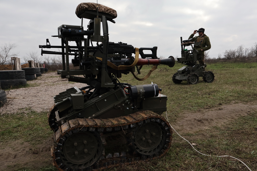 In this photo provided by Ukraine's 65th Mechanized Brigade press service, a soldier tests land drones in Zaporizhzhia region, Ukraine, Saturday, Dec. 6, 2025, (Andriy Andriyenko/Ukraine's 65th Mechanized Brigade via AP)