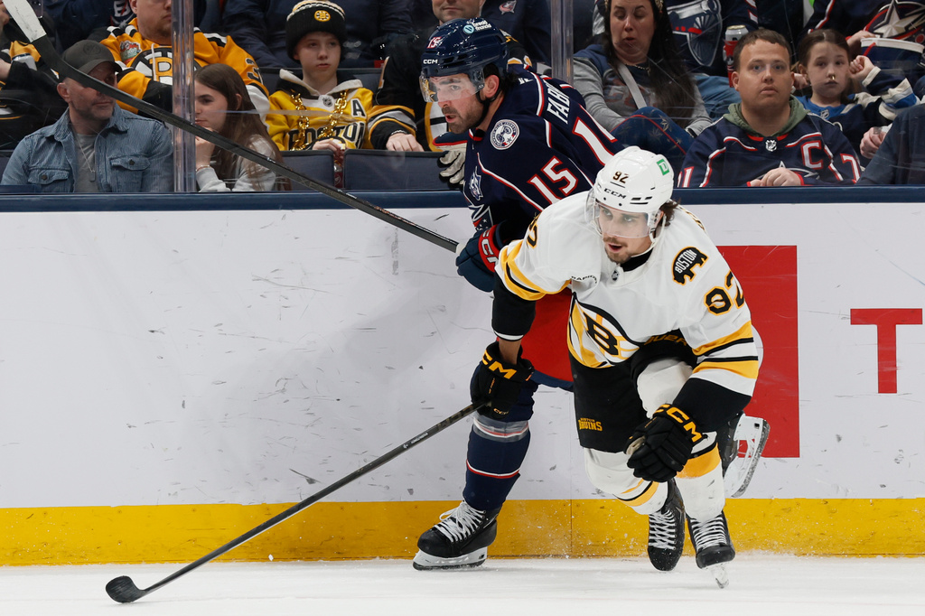 Columbus Blue Jackets' Dante Fabbro, left, and Boston Bruins' Marat Khusnutdinov chase the puck during the second period of an NHL hockey game, Sunday, March 29, 2026, in Columbus, Ohio. (AP Photo/Jay LaPrete)