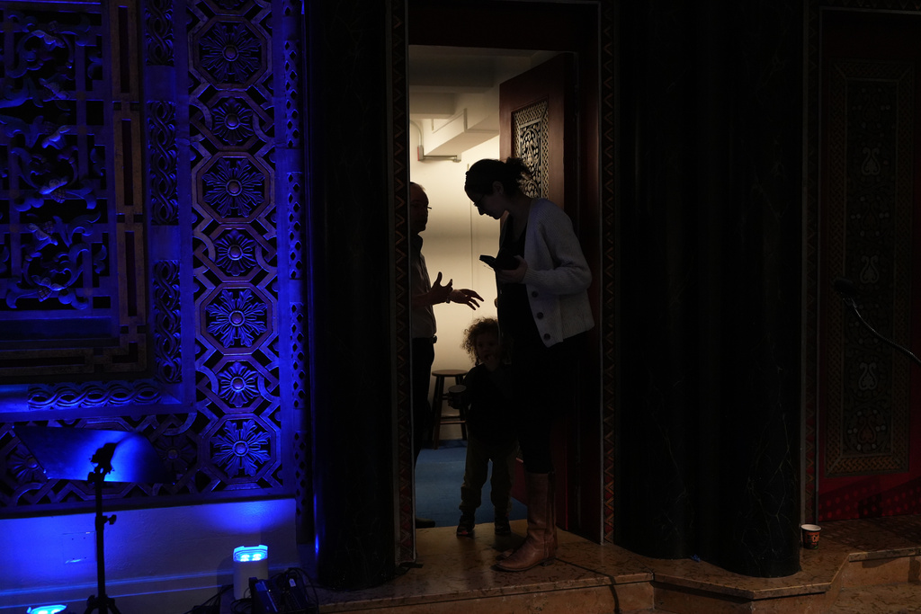Rebecca Weintraub, assistant rabbi of New York City's B'nai Jeshurun, talks to a member of the congregation on the sidelines of a Hannukah party held at the synagogue on Tuesday, Dec. 16, 2025. (AP Photo/Luis Andres Henao)