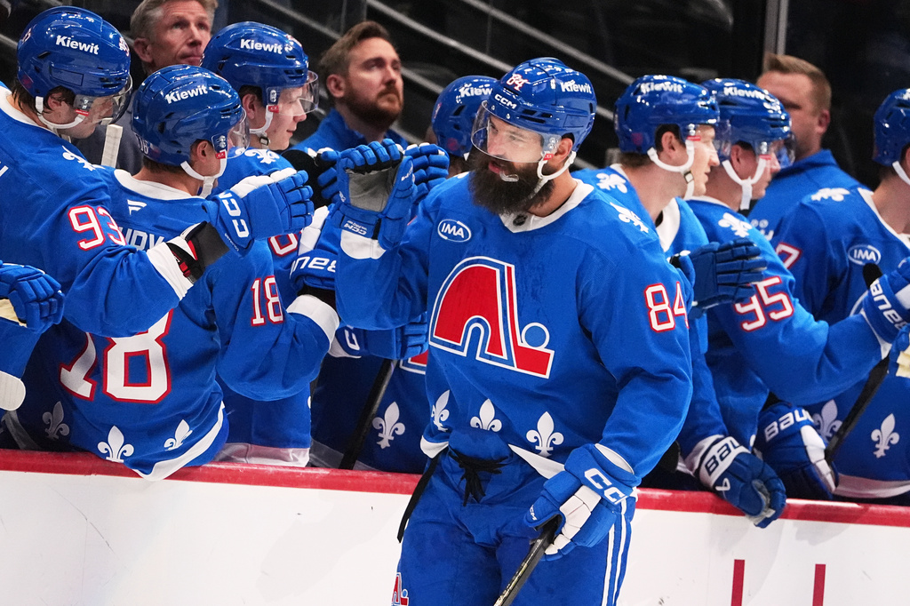 FILE - Colorado Avalanche defenseman Brent Burns is congratulated as he passes the team box after scoring a goal against the Montreal Canadiens in the second period of an NHL hockey game, Nov. 29, 2025, in Denver. (AP Photo/David Zalubowski, File)