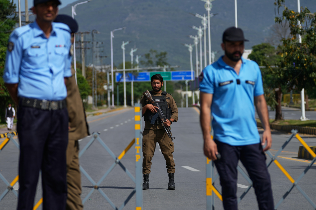 Police officers stand guard at a checkpoint on a barricaded to ensure security ahead of the second round of negotiations between the U.S. and Iran, in Islamabad, Pakistan, Tuesday, April 21, 2026. (AP Photo/Anjum Naveed)