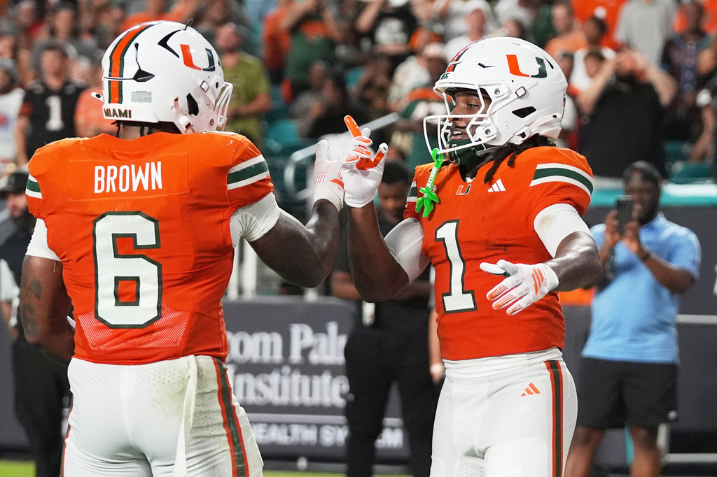 Miami wide receiver Malachi Toney (1) celebrates with running back Charmar Brown (6) after scoring a touchdown during the first half of an NCAA college football game against Florida A&M, Thursday, Sept. 10, 2026, in Miami Gardens, Fla. (AP Photo/Lynne Sladky)