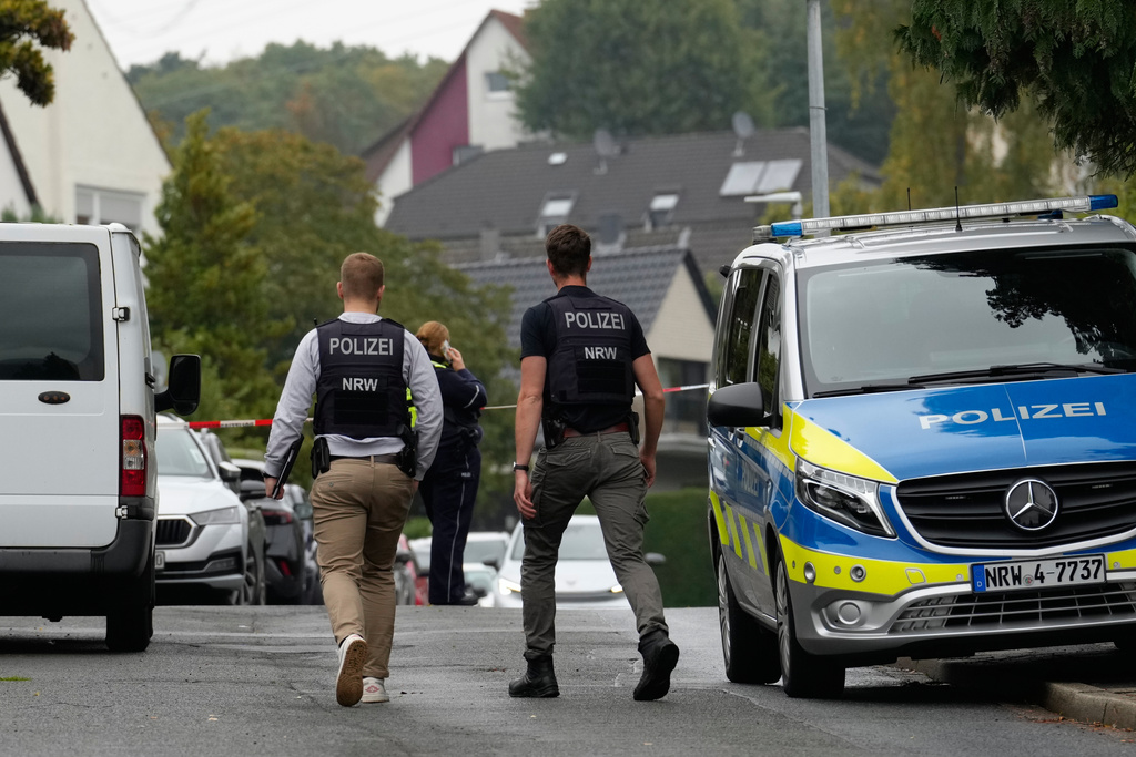 Police officers across a street in Herdecke, Germany, Tuesday, Oct. 7, 2025, after the newly elected mayor of Herdecke, Iris Stalzer, has been found critically injured in her apartment. (AP Photo/Martin Meissner)